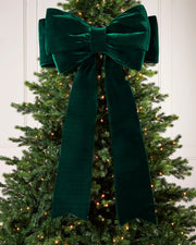 Large 140cm sage green velvet Christmas bow displayed on a lit Christmas tree