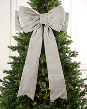Large 140cm silver velvet Christmas bow displayed on a lit Christmas tree