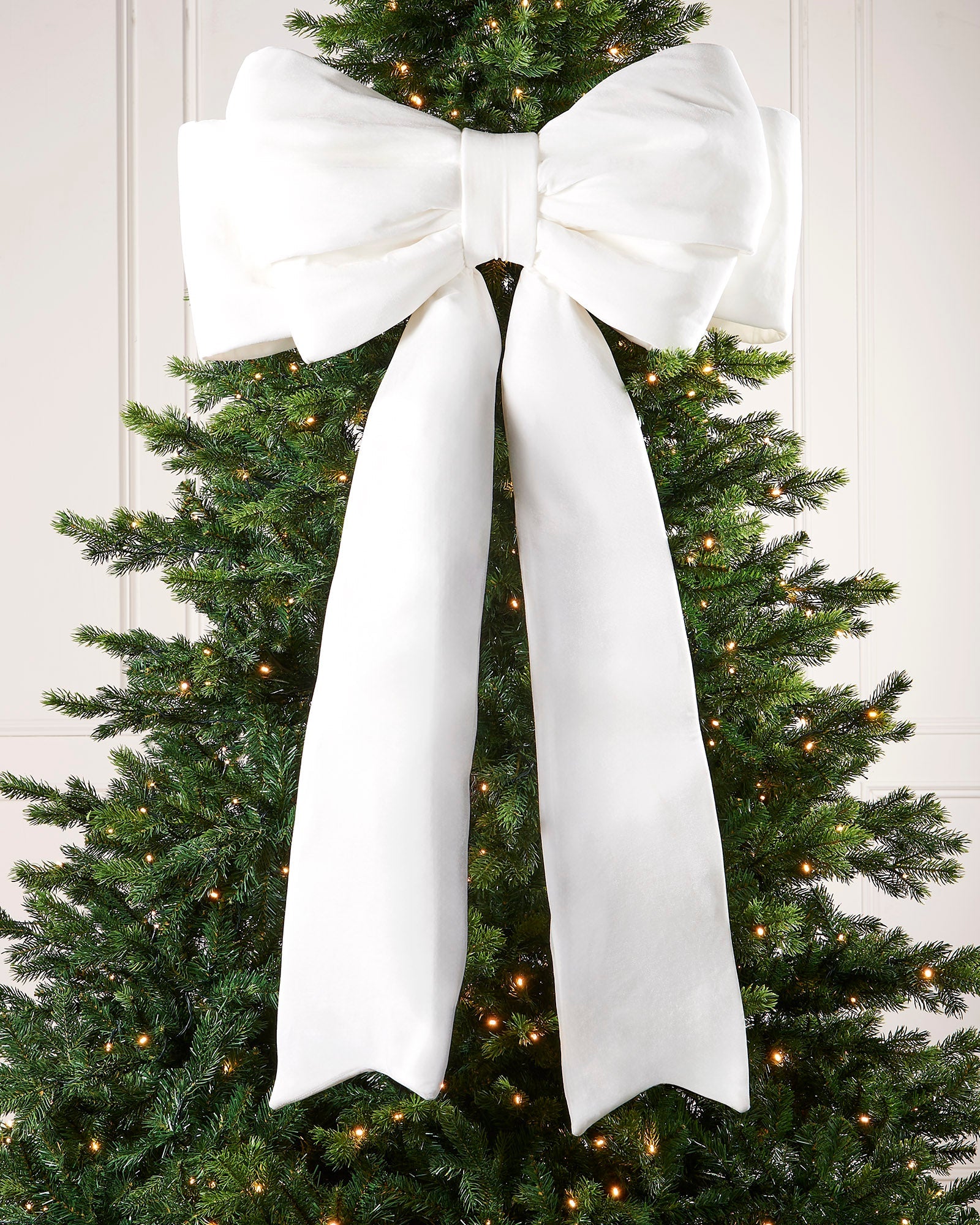 Large 140cm white velvet Christmas bow displayed on a lit Christmas tree