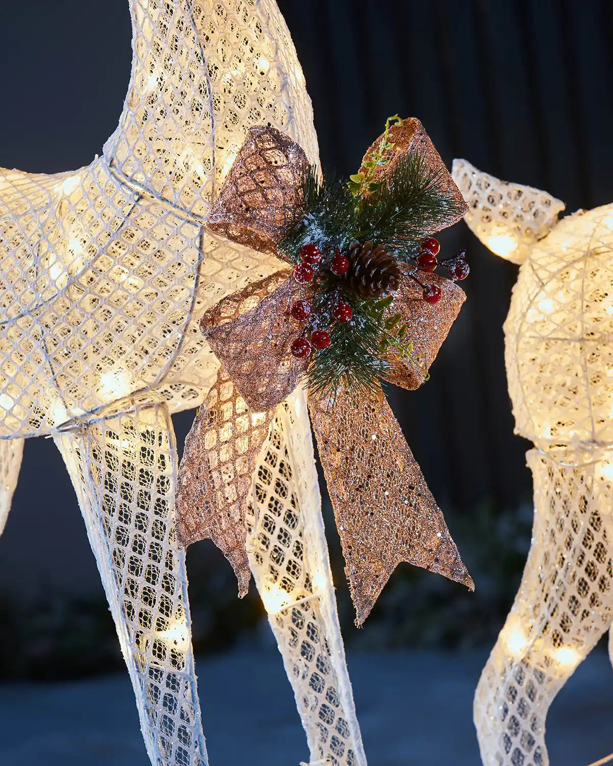 Close-up of the decorative bow and berry detail on the pre-lit 3D reindeer pair