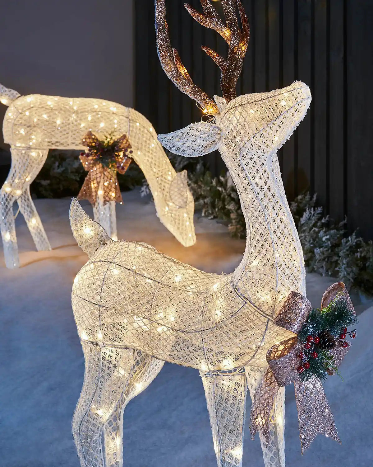 Close-up lifestyle view of the pre-lit 3D reindeer pair with white mesh finish
