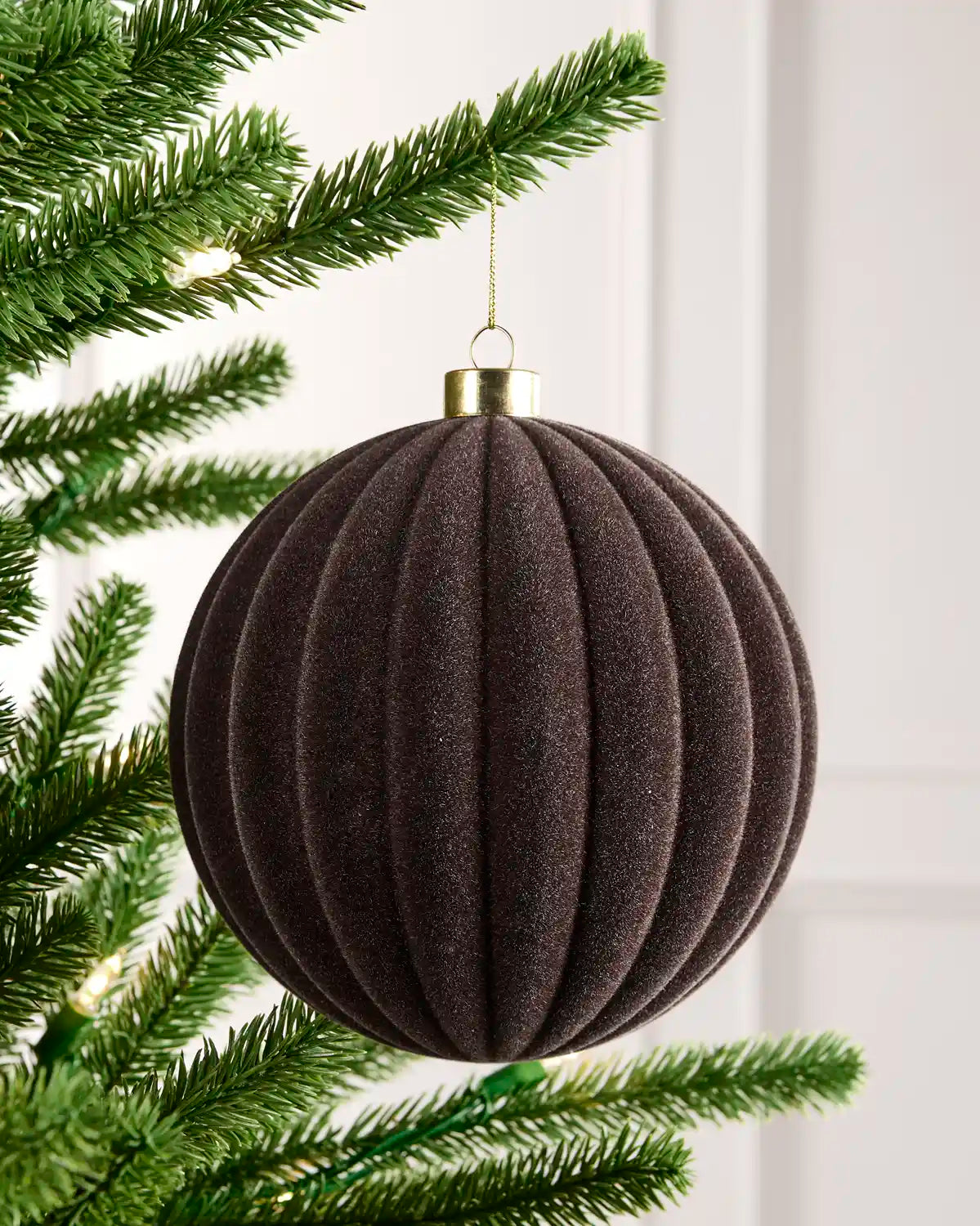 15 cm Espresso oversized velvet Ribbed bauble hanging from a Christmas tree with a gold cap.
