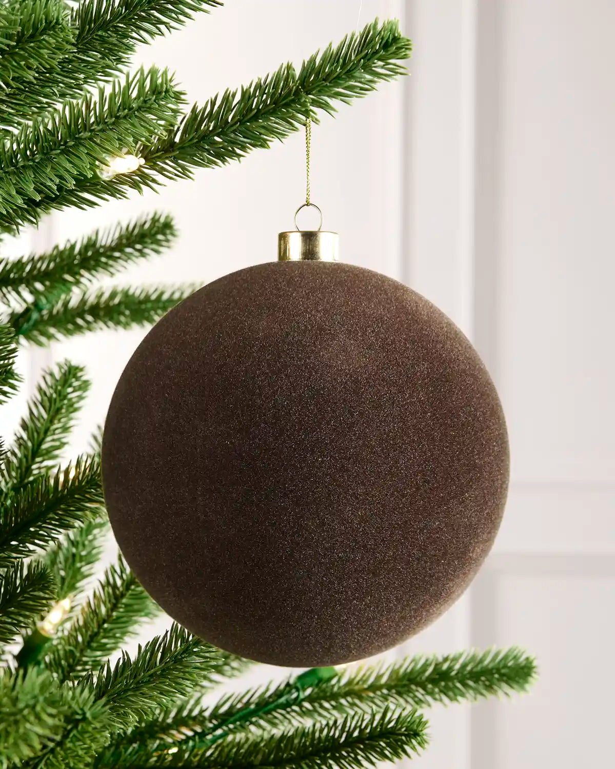15 cm Mocha oversized velvet Traditional bauble hanging from a Christmas tree with a gold cap.
