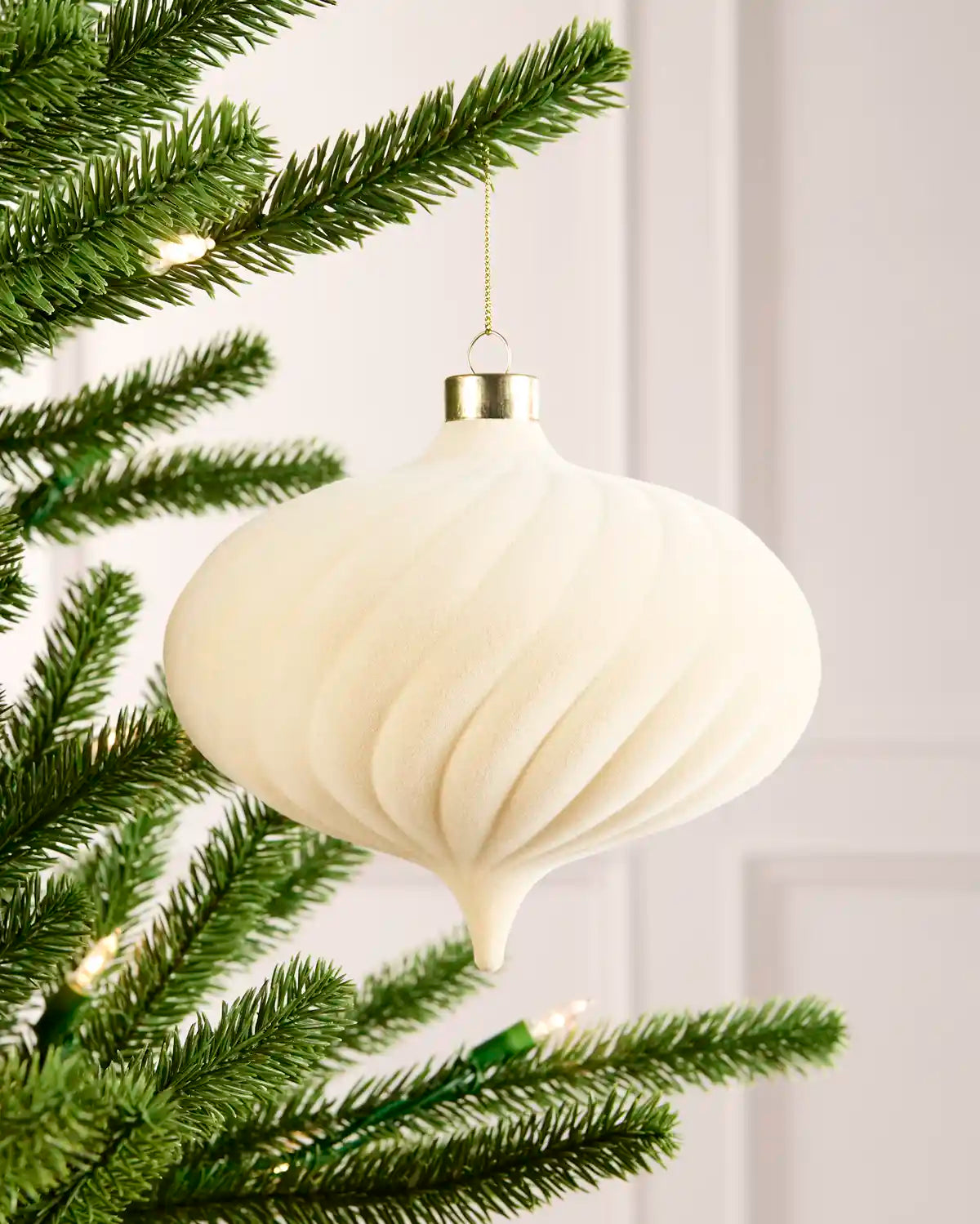15 cm latte oversized velvet Spiral bauble hanging from a Christmas tree with a gold cap.
