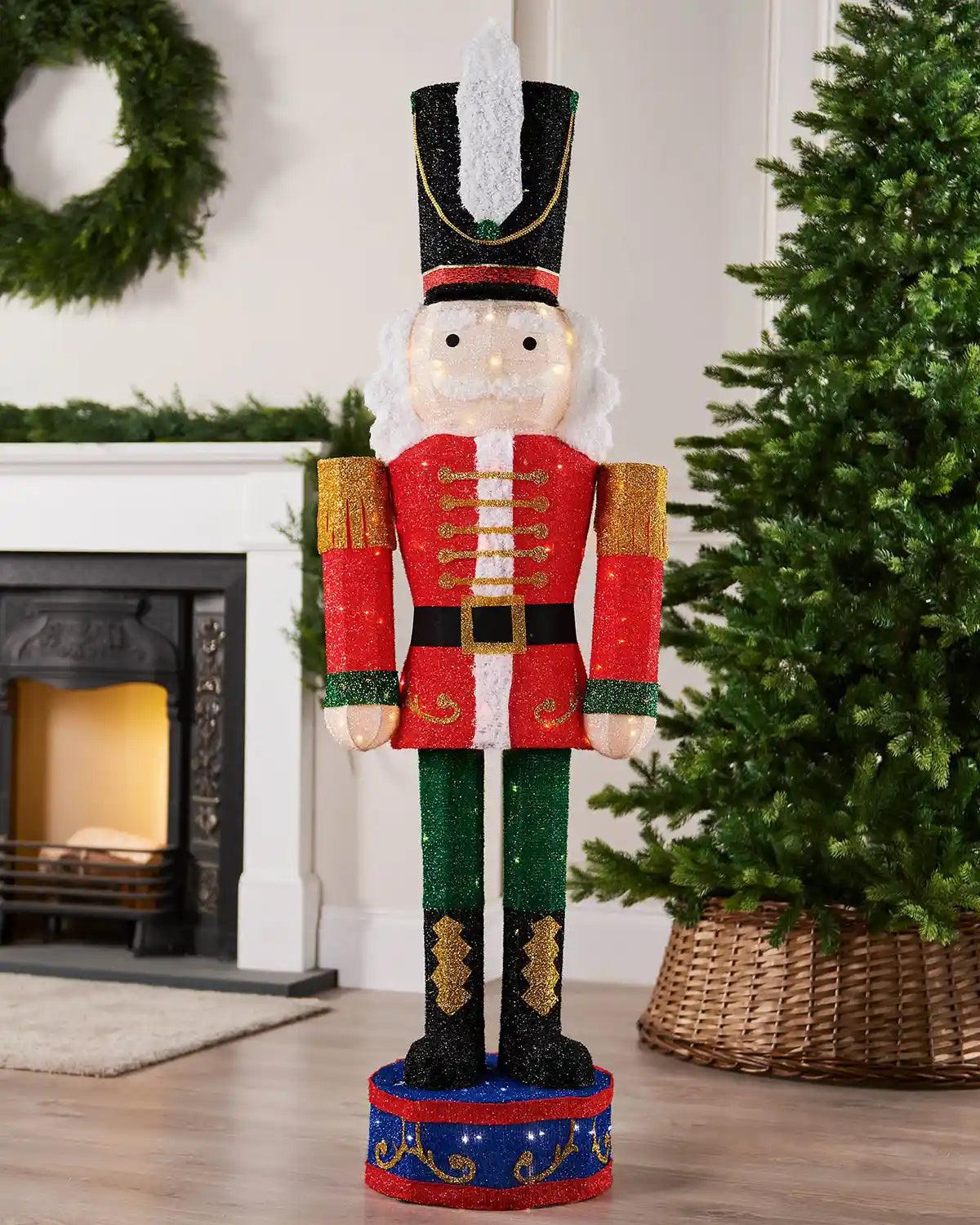 165cm pre-lit 3D nutcracker silhouette displayed indoors beside a Christmas tree and fireplace.