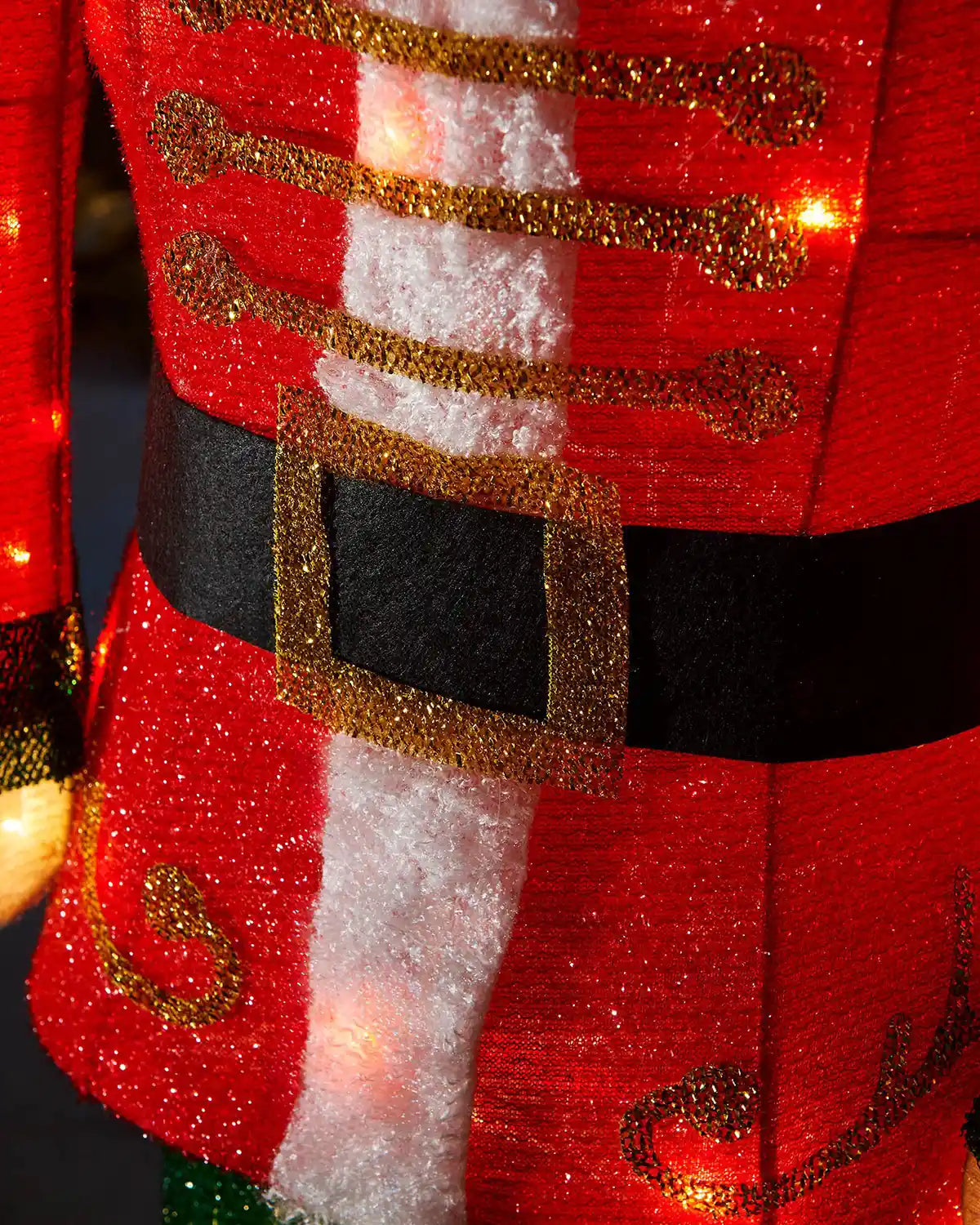 Close-up of the 165cm nutcracker’s red jacket with gold detailing, black belt and warm white lights.