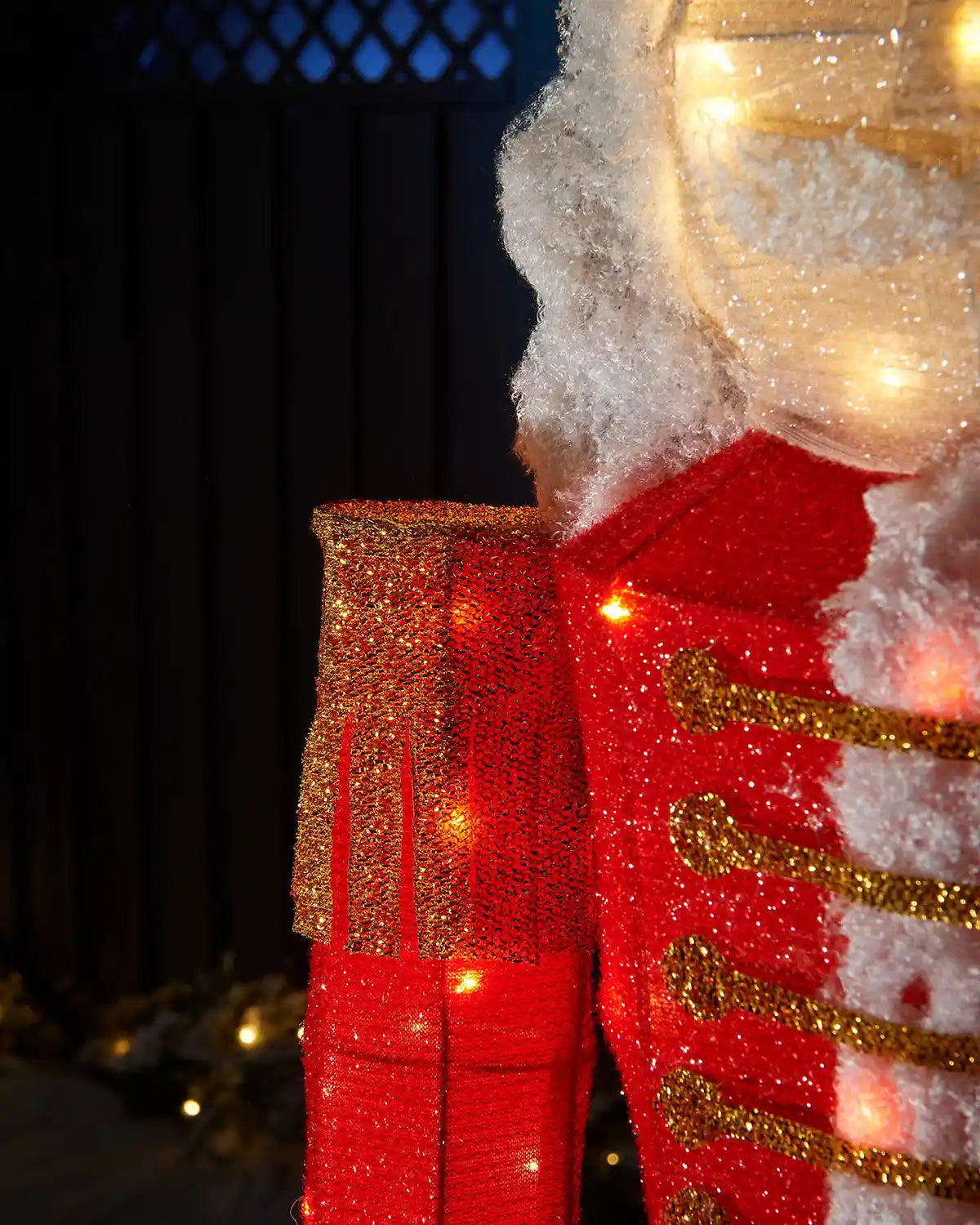 Detail of the pre-lit nutcracker’s red jacket, gold shoulder panel and white hair.