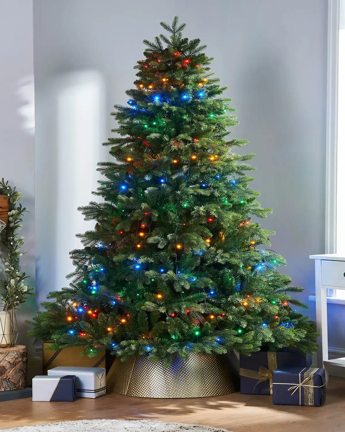 192 LED Christmas Tree String Lights, Multi Colour, 2 m on a Christmas Tree with Presents under on a light blue background 