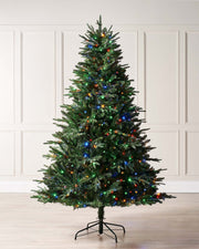 A pre-lit Grand Windsor fir Christmas tree with a full silhouette, featuring mixed PE and PVC tips and dual-function LEDs that switch between warm white and multicolour. Displayed indoors against a plain background.