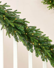 Christmas garland with lights on a neutral background