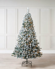 Snow-flocked mixed pine Christmas tree with realistic V-cut and bullet tips, featuring built-in warm white LED lights and a full, natural silhouette. Displayed against a plain background.