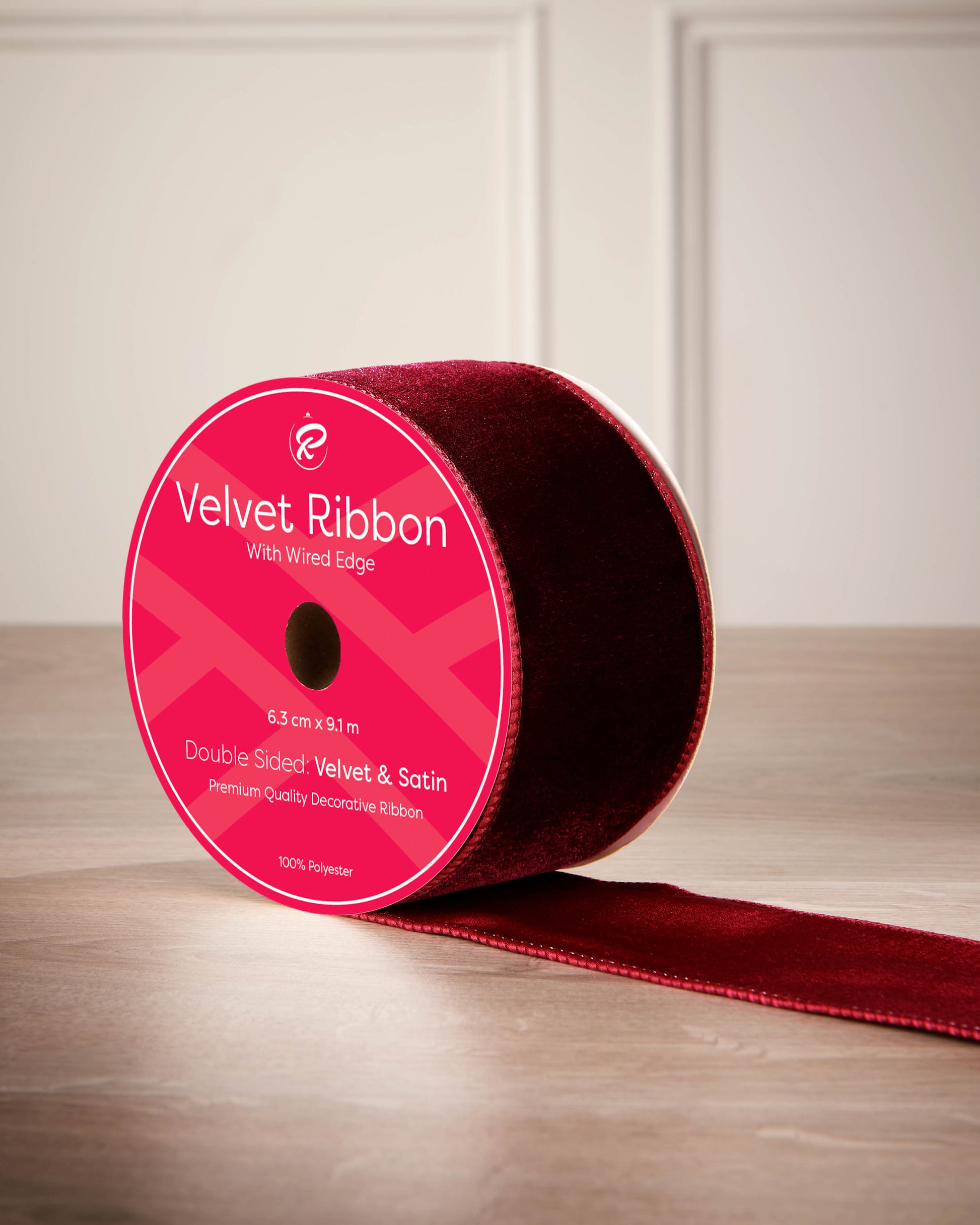 Red velvet ribbon with a pink label on a wooden surface