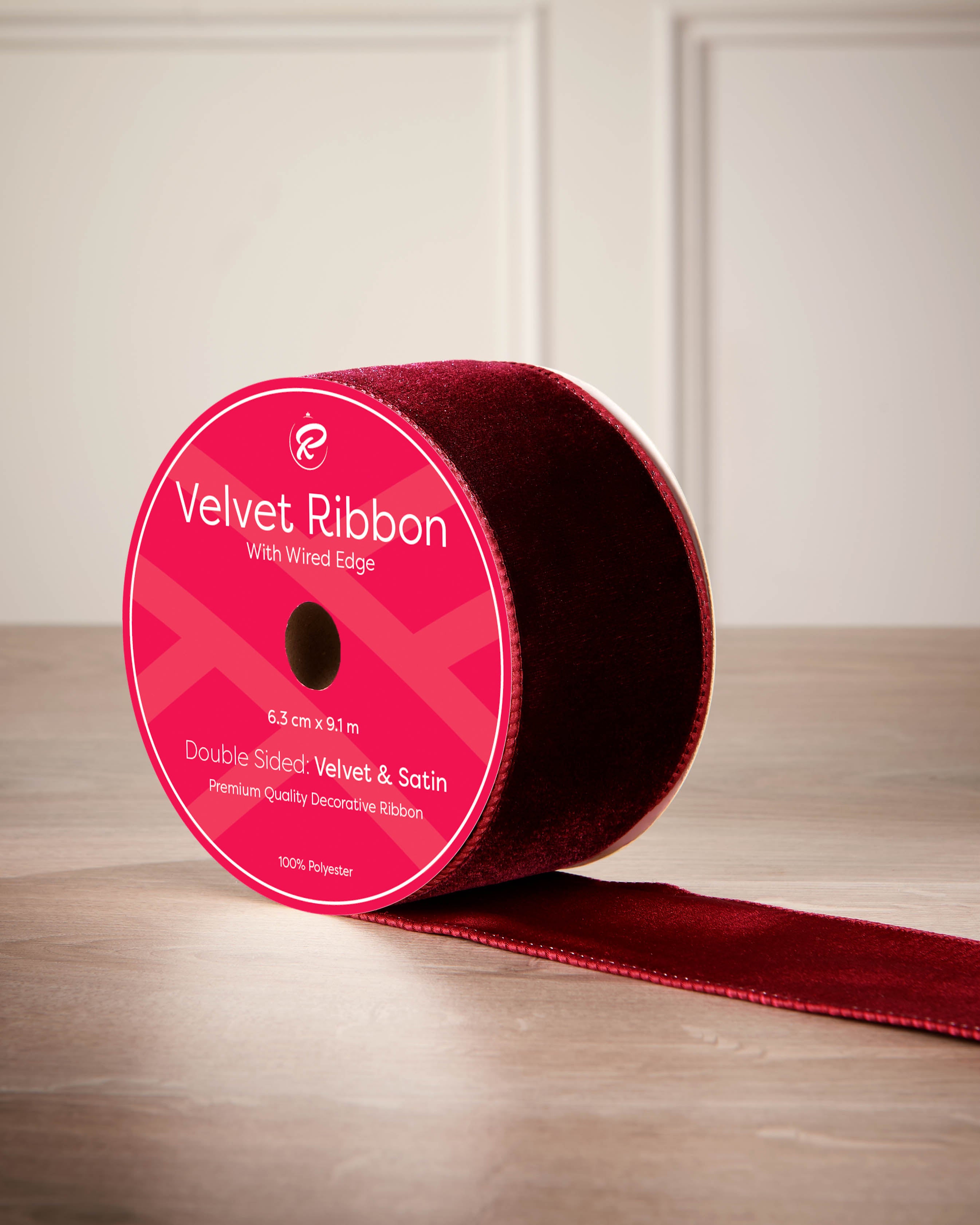 Red velvet ribbon with a pink label on a wooden surface