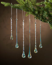Decorative glass ornaments shaped like hanging drops on a Christmas tree.