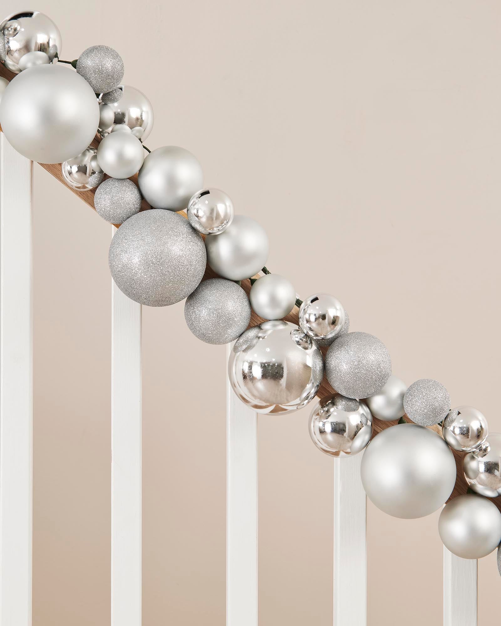Decorative wreath made of silver and gray ornaments on a neutral background