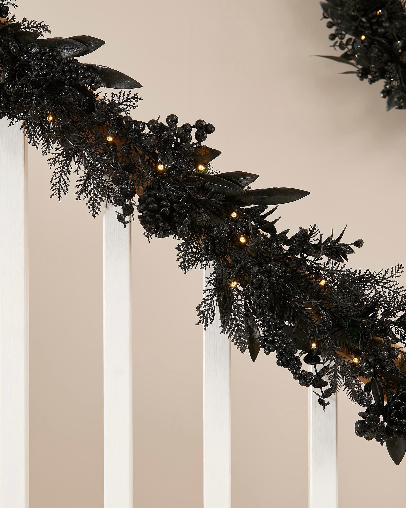 Decorative black garland with lights on a neutral background