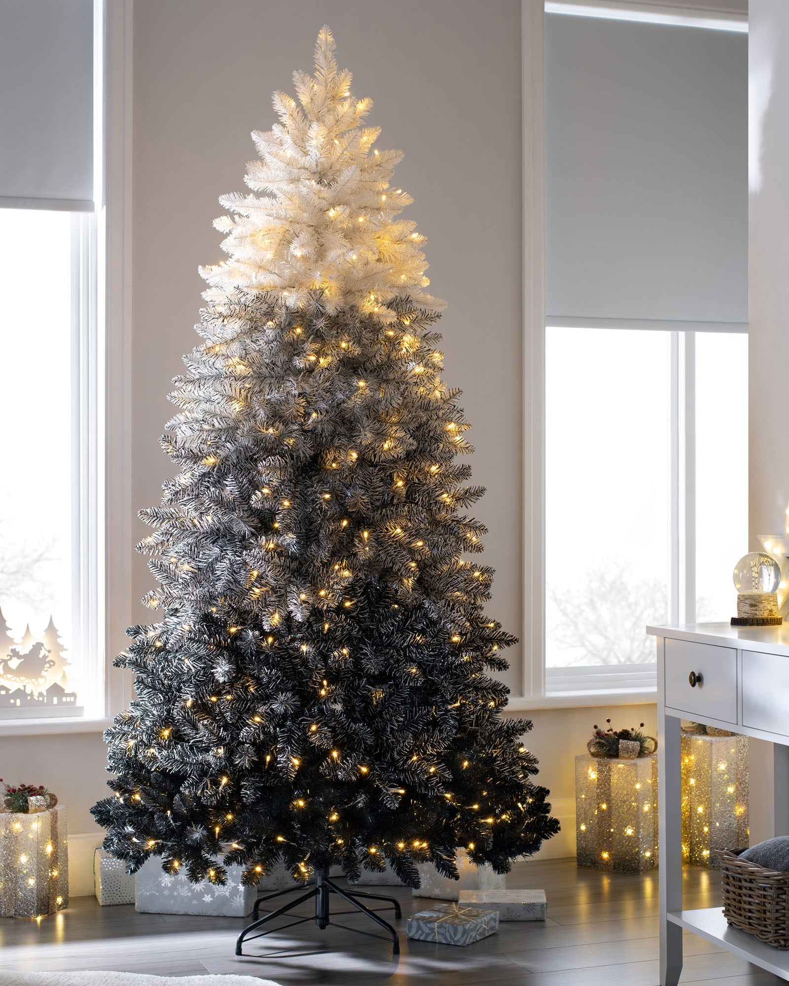 Pre-lit Ombre Christmas tree with a dark-to-light gradient, warm white LED lights, and a full, elegant shape, displayed indoors on a foldable metal stand.