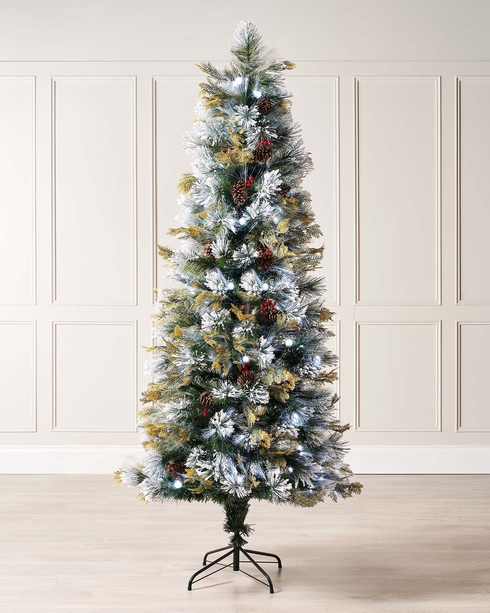 Pre-lit Christmas tree with snow-flocked pinecones and red berries, featuring fibre optic and warm white LED lights. Compact size on a foldable metal stand, showcasing snowy branches and festive decorations.