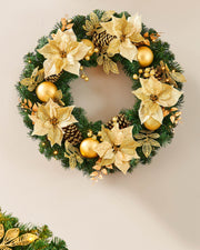 Decorative Christmas wreath with gold flowers and ornaments on a plain background