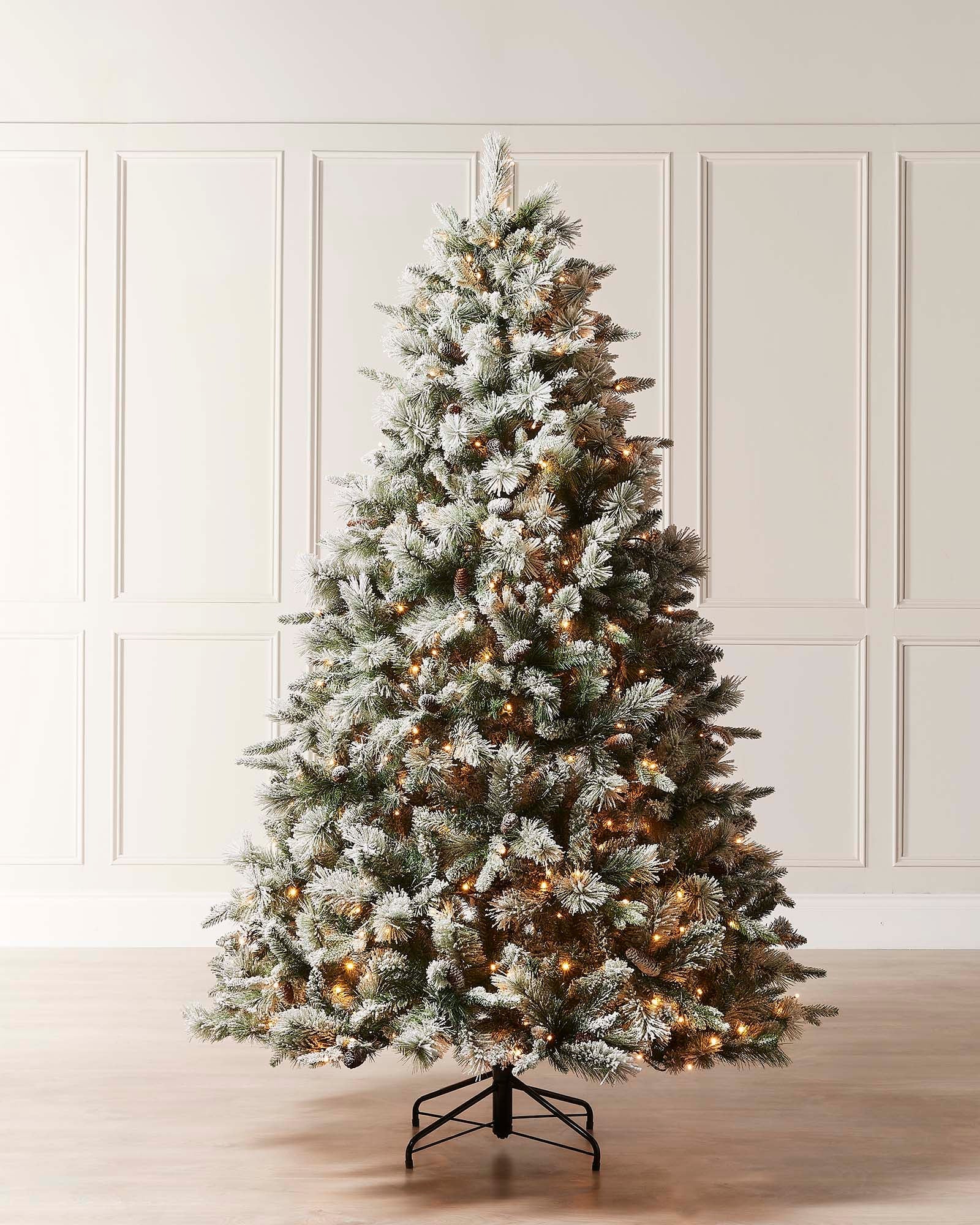 An 8-foot pre-lit snow-flocked mixed pine Christmas tree displayed against a neutral background.