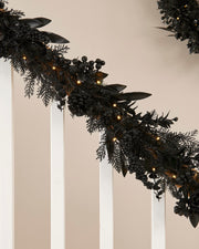 Decorative black garland with lights on a neutral background