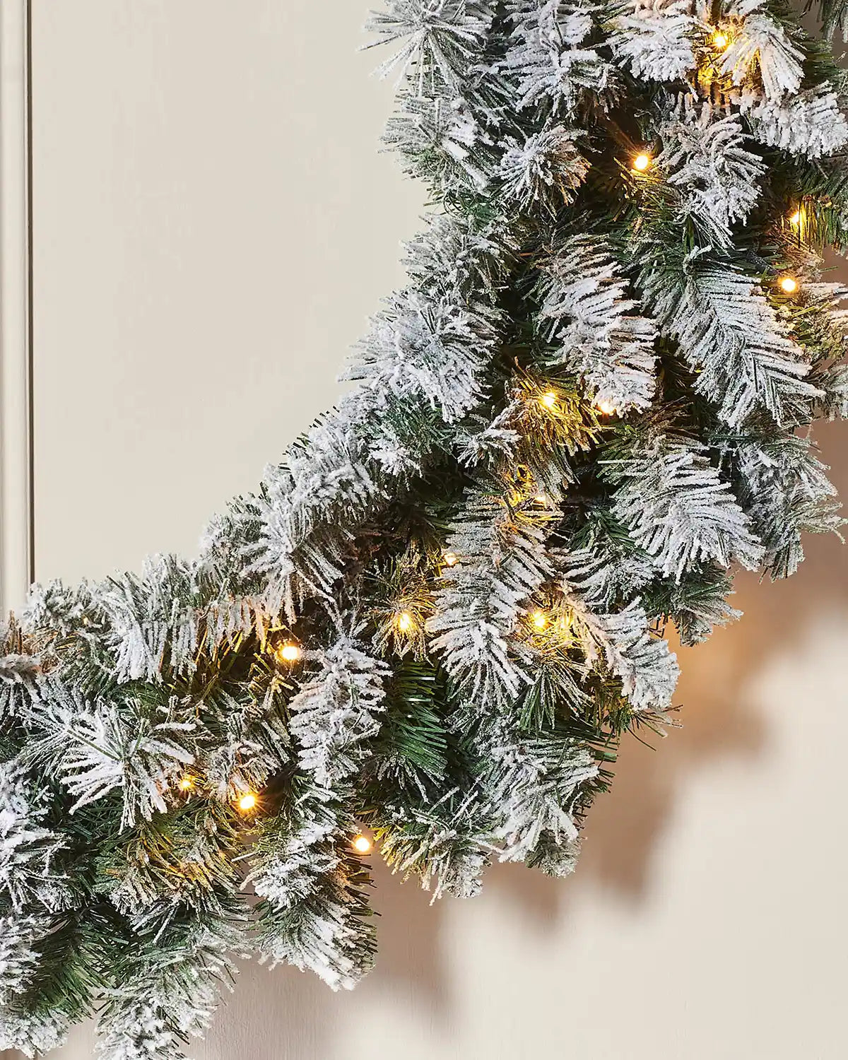 Close-up of snow-flocked foliage and warm white LEDs on 1 m majestic wreath