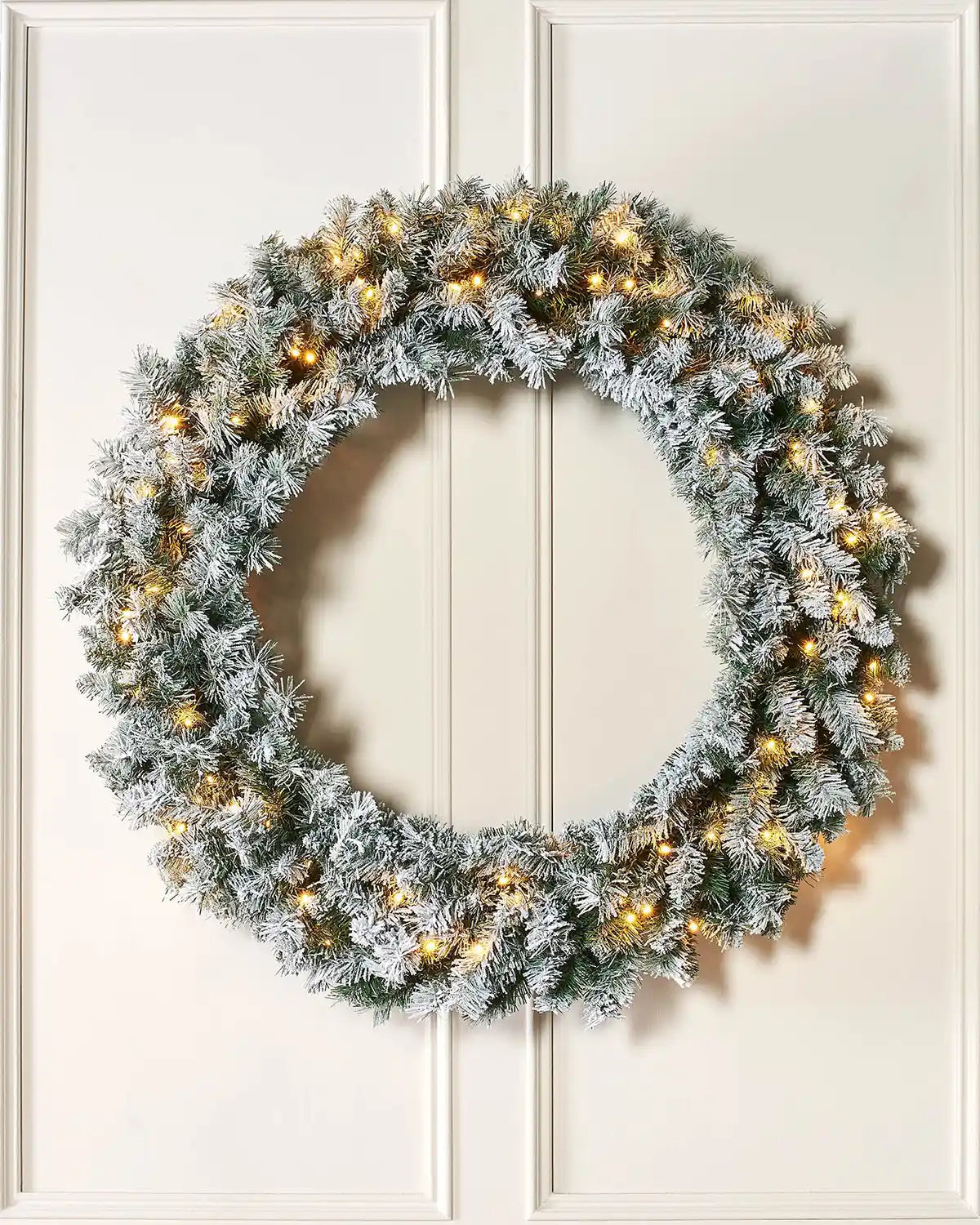 Full 1 m pre-lit snow-flocked majestic wreath displayed on a lifestyle wall