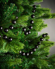 2.7m black oversized beaded garland draped through green Christmas tree branches.