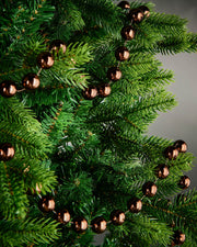 2.7m espresso oversized beaded garland draped through green Christmas tree branches.