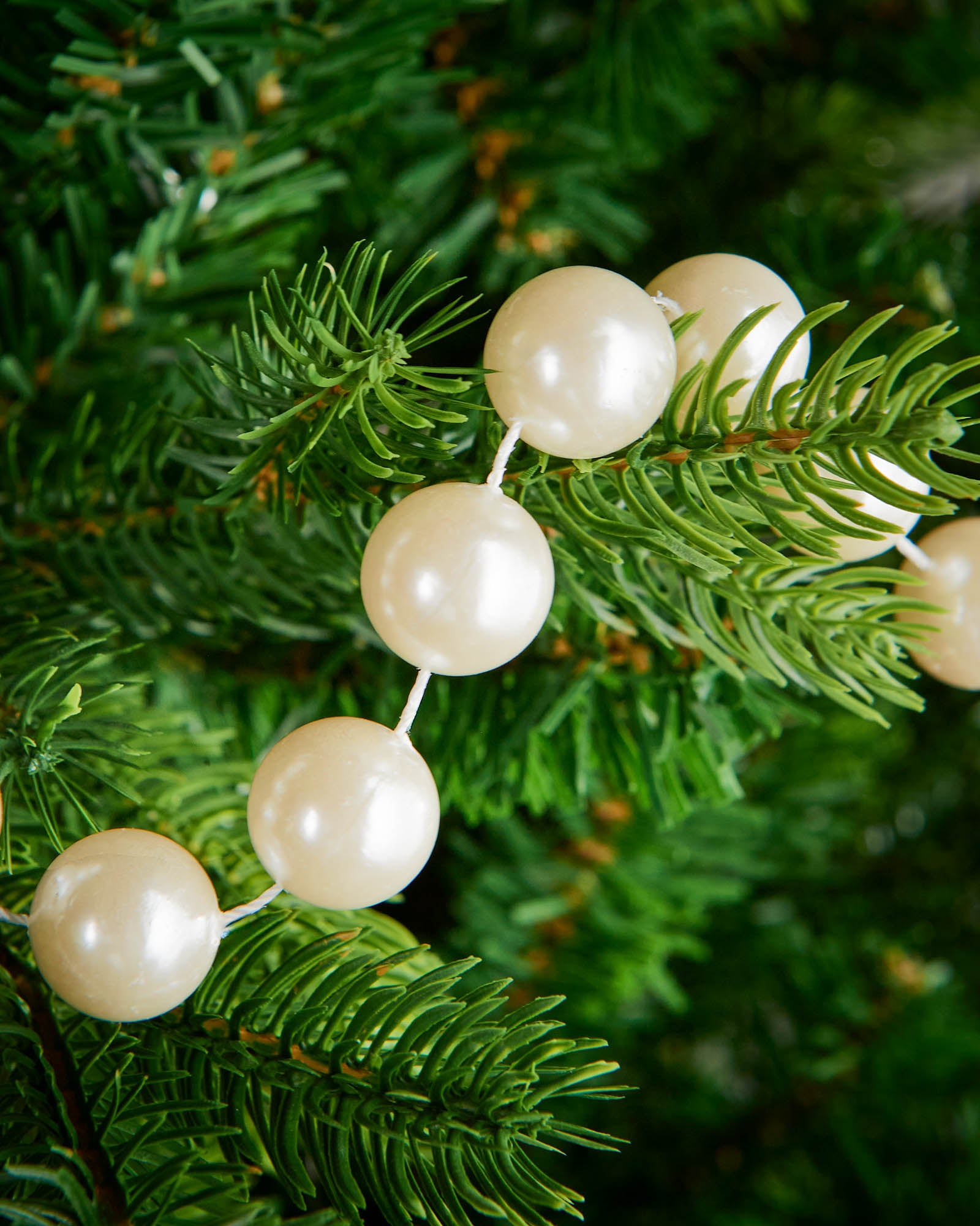 Close-up of glossy latte beads on a 2.7m oversized garland displayed on a Christmas tree.