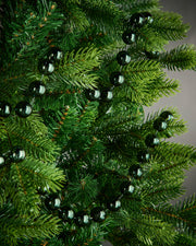 2.7m sage green oversized beaded garland draped through green Christmas tree branches.