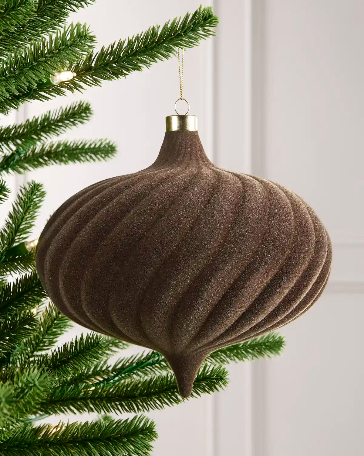 20 cm Mocha oversized velvet Spiral bauble hanging from a Christmas tree with a gold cap.

