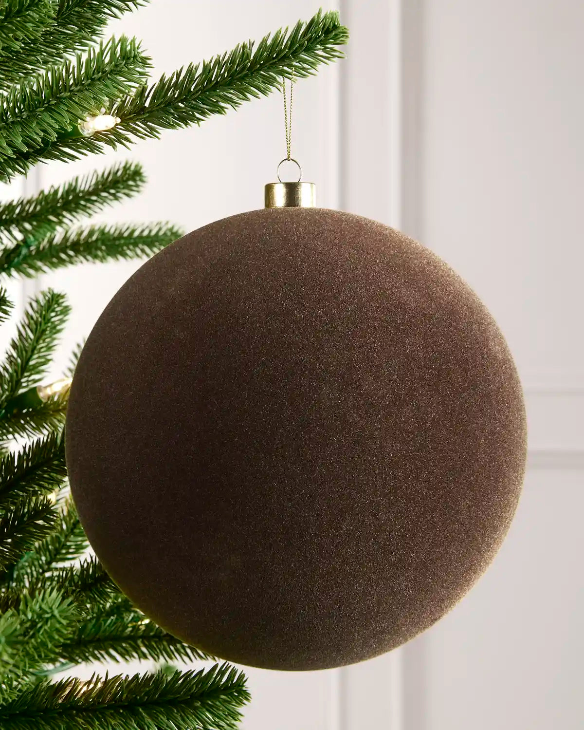 20 cm Mocha oversized velvet Traditional bauble hanging from a Christmas tree with a gold cap.
