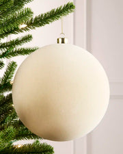 20 cm latte oversized velvet Traditional bauble hanging from a Christmas tree with a gold cap.
