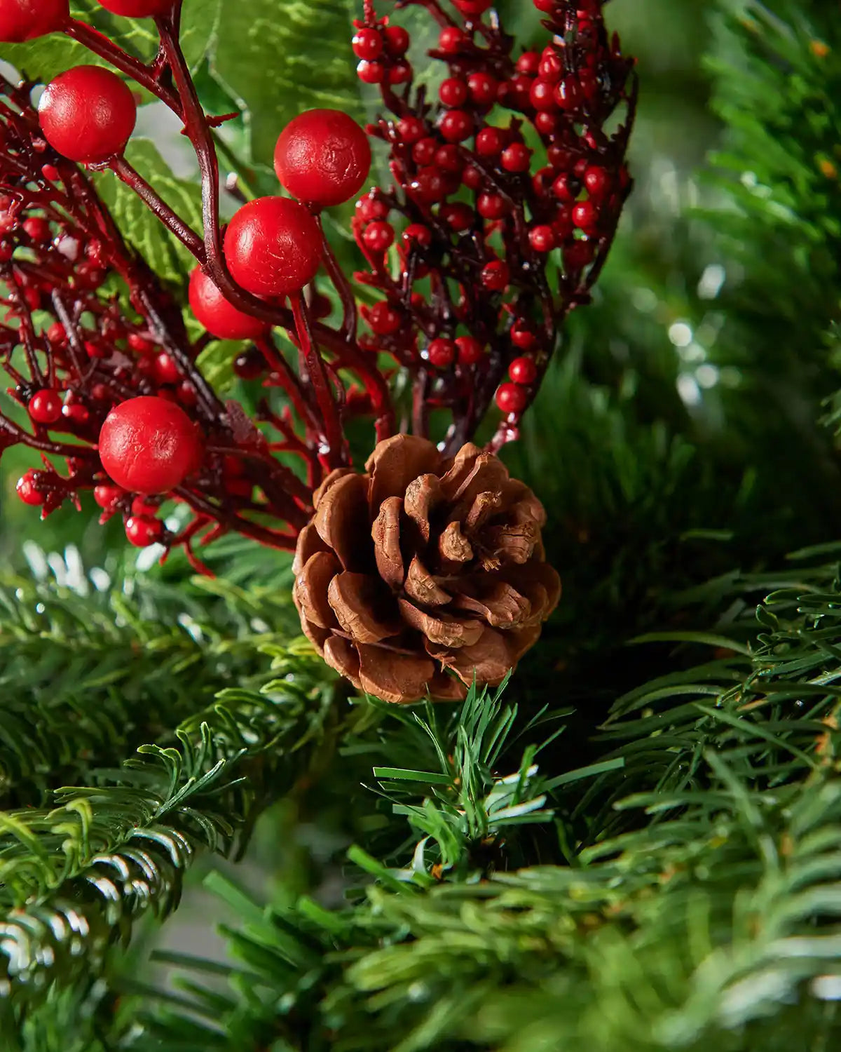 Close-up of the red berries and pinecone detail on the 20 cm artificial tree pick