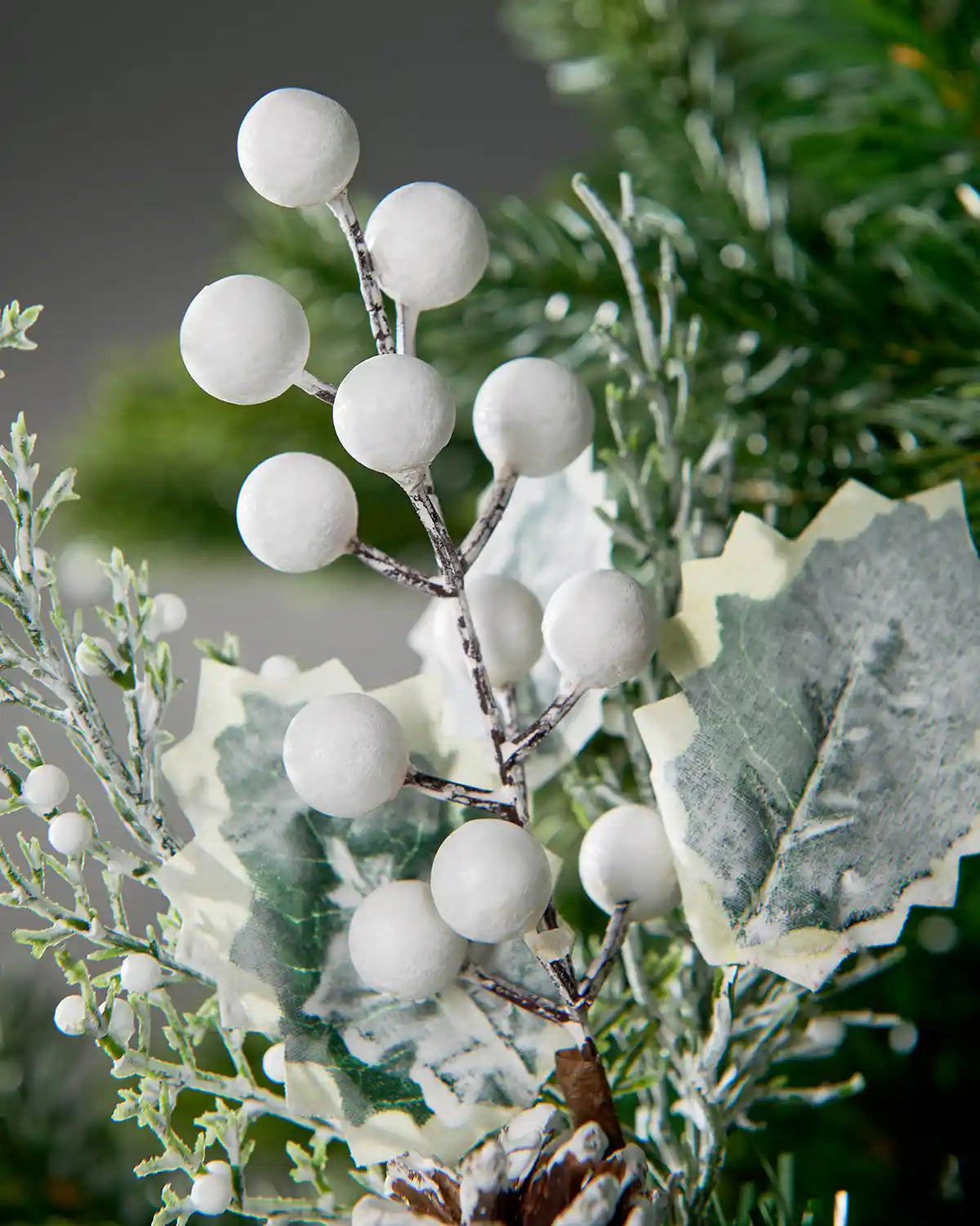 Detail of the white frosted berries and holly-style leaves on the 20 cm artificial pick