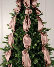 Mocha satin ribbon woven through a Christmas tree as part of a festive indoor display.