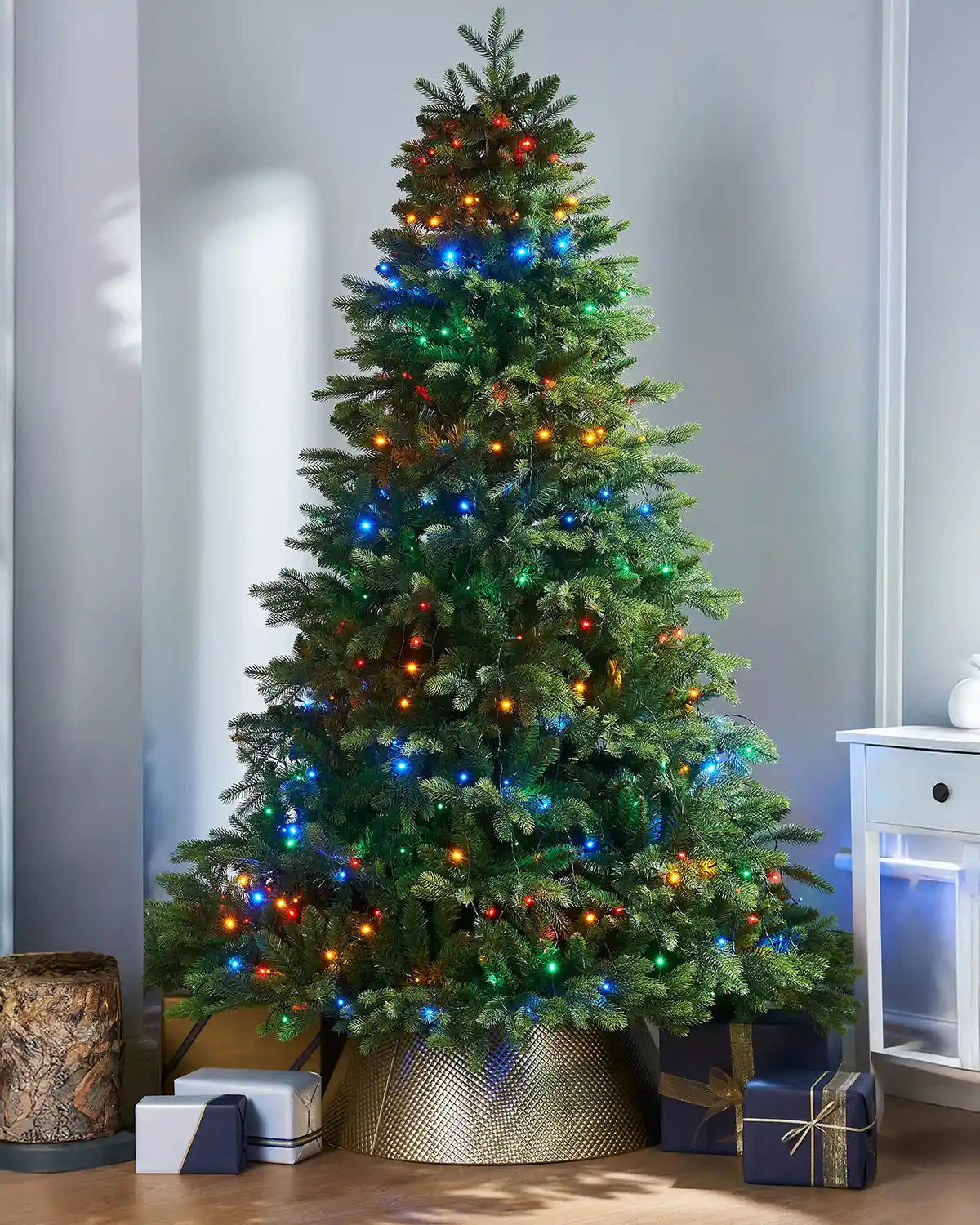 240 LED Christmas Tree Light String, Multi Colour, 2.5 m on a Christmas Tree with presents under the tree on a light blue background