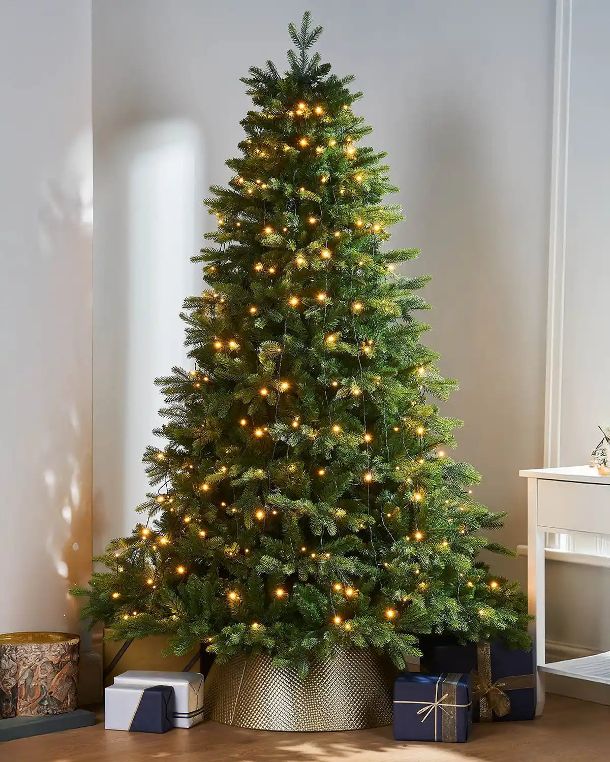 240 LED Christmas Tree String Lights, Warm White, 2.5 m on a Christmas tree and presents under the tree on a cream background