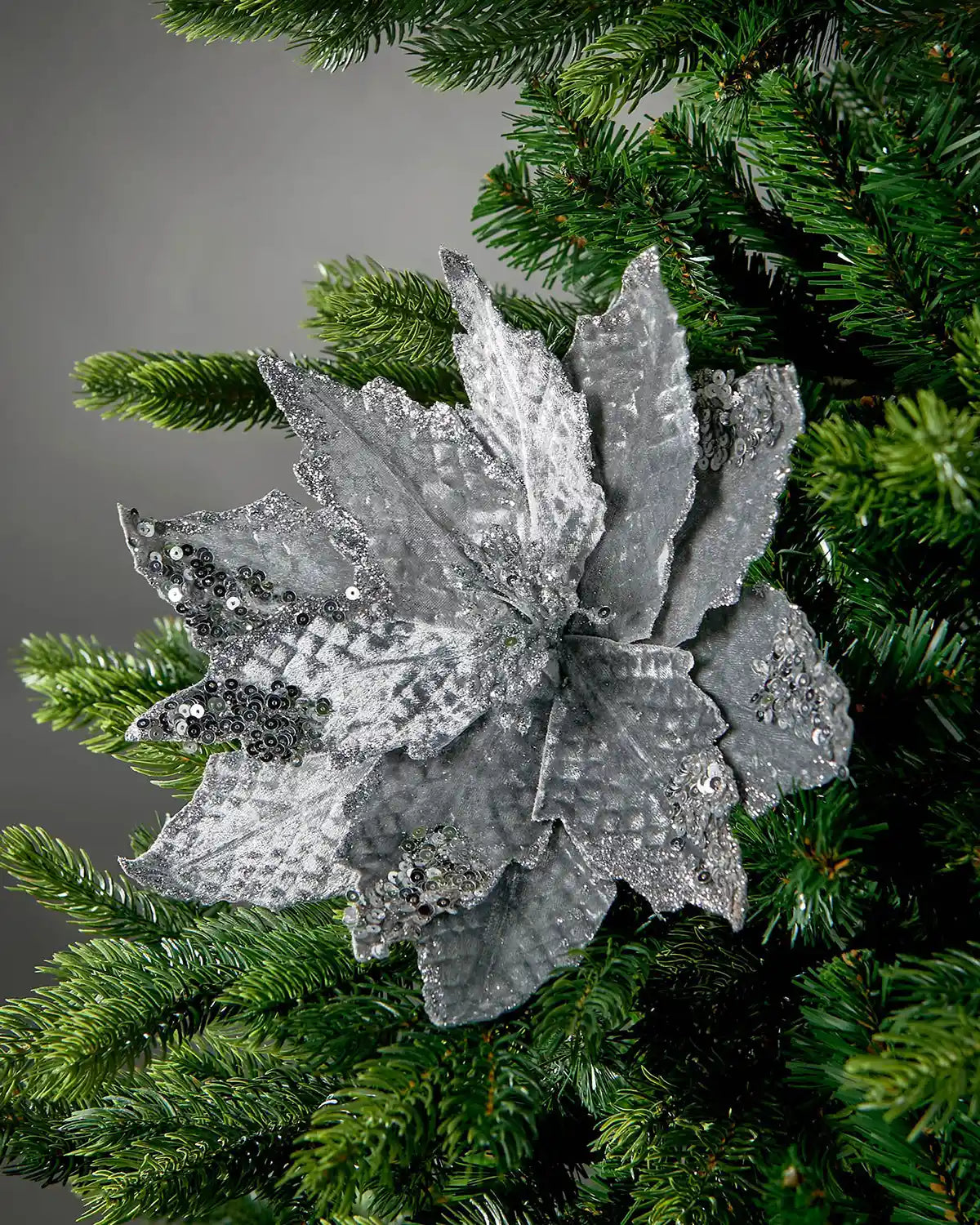 Silver artificial poinsettia flower styled in a Christmas tree