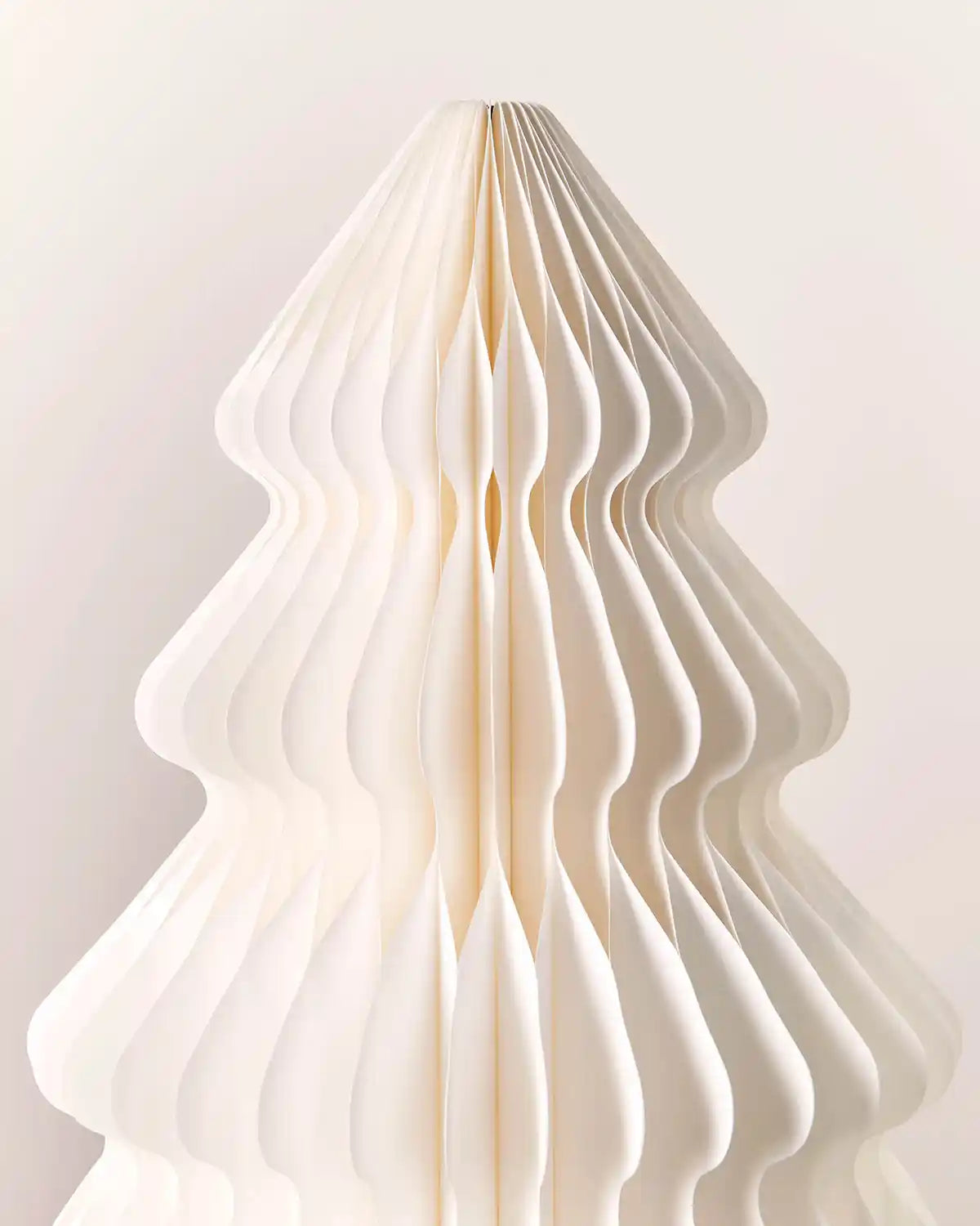 Close-up of the layered off-white paper honeycomb design on a Christmas tree decoration.
