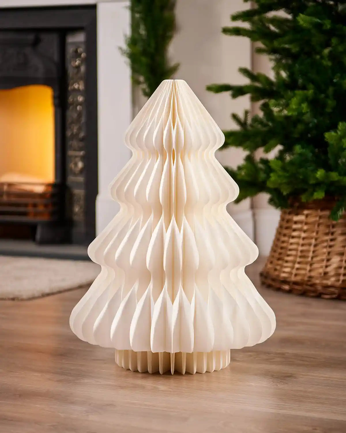 2ft off-white paper honeycomb Christmas tree displayed indoors beside a fireplace.
