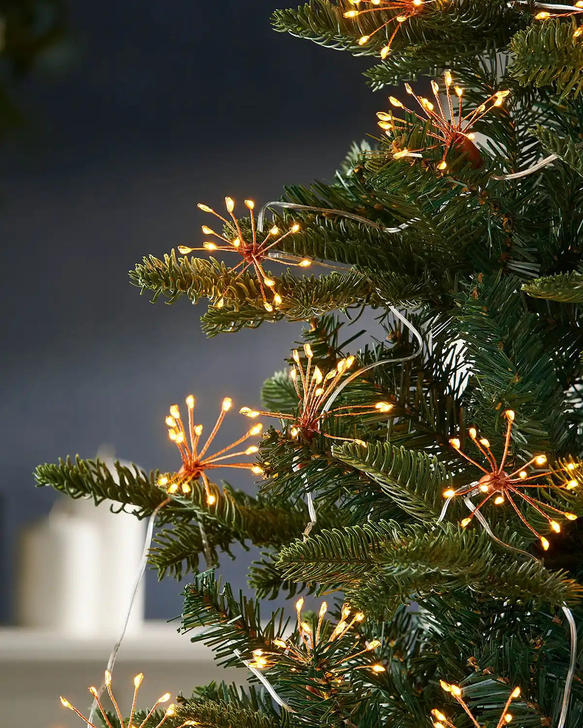 Close-up of 2 m copper wire firework string lights styled on a Christmas tree