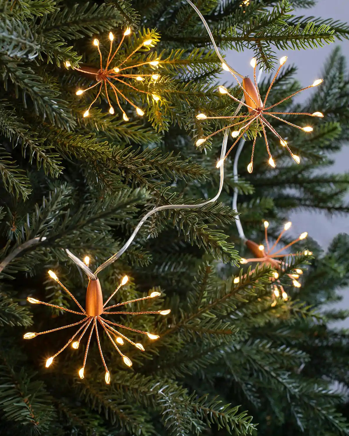 2 m copper wire firework string lights displayed on a Christmas tree