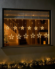 2m warm white star curtain light hanging in a window with star shapes and vertical light strands