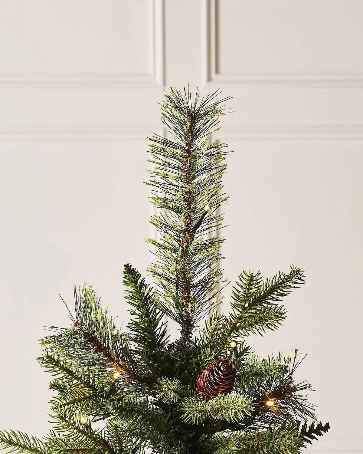 Top section of a 3.5 ft pre-lit natural pine Christmas tree with pinecone accents and warm white lights