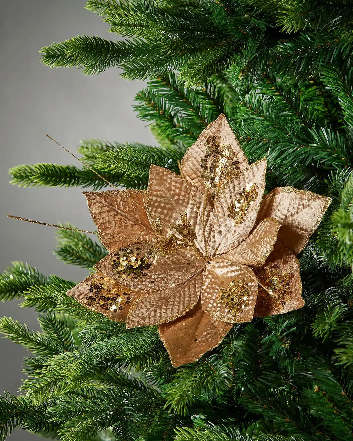 Gold artificial poinsettia flower styled in a Christmas tree