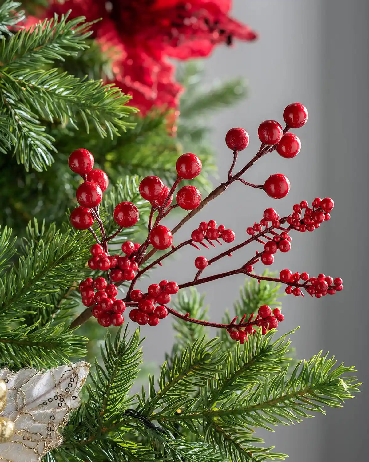 Close-up of the 30 cm red artificial berries tree pick styled in a Christmas tree