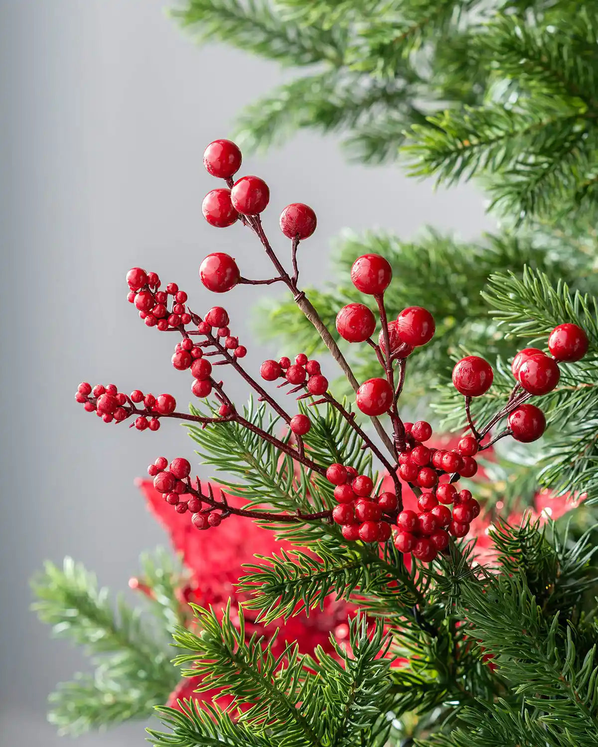 30 cm red artificial berries tree pick displayed in a Christmas tree with red festive décor