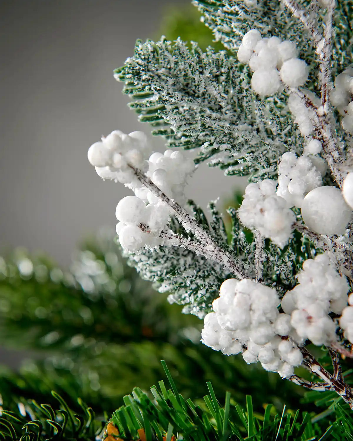 Close-up of the white berries and snow-dusted pine foliage on the 31 cm artificial pick
